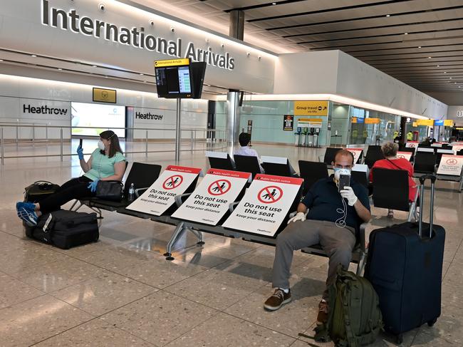 Passengers seated apart wearing face mask and gloves at London’s Heathrow Airport. Picture: AFP