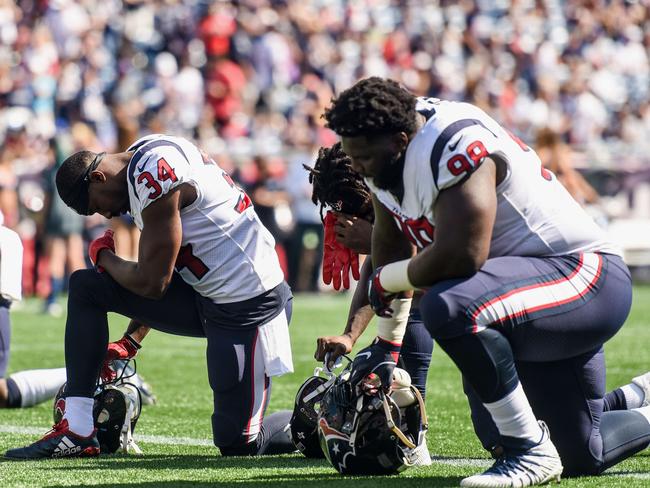 FOXBORO, MASSACHUSETTS - SEPTEMBER 24: Members of the Houston Texans kneel before a game against the New England Patriots at Gillette Stadium on September 24, 2017 in Foxboro, Massachusetts.   Billie Weiss/Getty Images/AFP == FOR NEWSPAPERS, INTERNET, TELCOS & TELEVISION USE ONLY ==