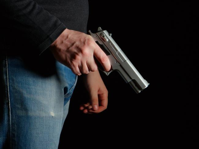 GENERIC PICTURE: Man with a gun in a dark room, man holding gun