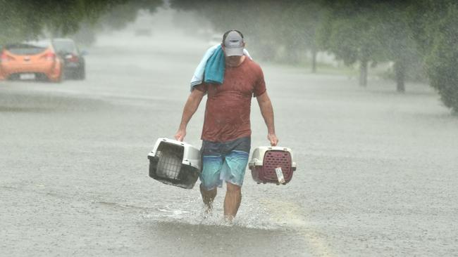 Sunday February 2. Heavy rain lashes Townsville causing flash flooding. Peter Sharpe carries a pair of cats to safety in Carmody Street, Rosslea.Picture: Evan Morgan