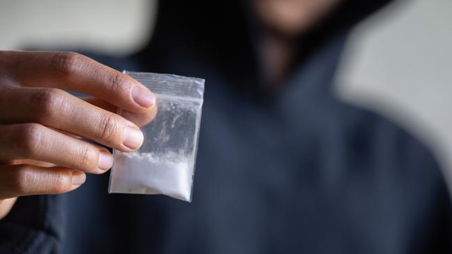 Hand of addict man holding cocaine or heroine, close up of addict buying dose from drug dealer, drug trafficking, crime, addiction and sale concept, istock image