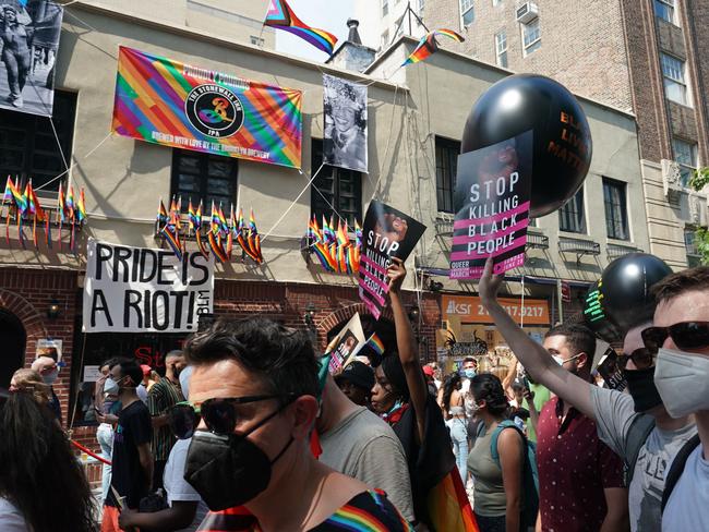 Protesters carrying signs walk past the Stonewall Inn during the Queer Liberation March hosted by The Reclaim Pride Coalition for Trans and Queer black lives and against police brutality in lower Manhattan on June 28, 2020 in New York. (Photo by Bryan R. Smith / AFP)