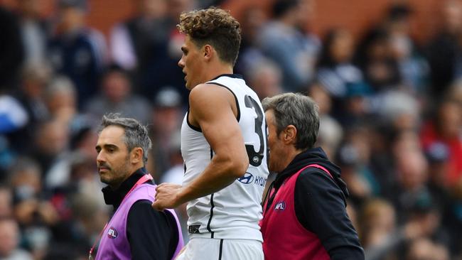 Charlie Curnow limps from the field after injuring his knee. Picture: AAP Image/David Mariuz. 