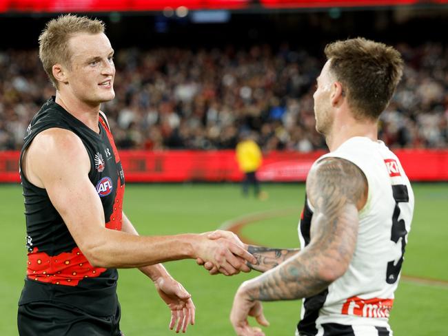 MELBOURNE, AUSTRALIA - APRIL 25: Jamie Elliott of the Magpies and Mason Redman of the Bombers shake hands after the game ends in a draw during the 2024 AFL Round 07 match between the Essendon Bombers and the Collingwood Magpies at the Melbourne Cricket Ground on April 25, 2024 in Melbourne, Australia. (Photo by Dylan Burns/AFL Photos via Getty Images)