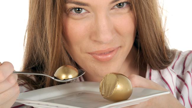 Your Money superannuation generic images. Woman eating golden nest egg with spoon from plate.