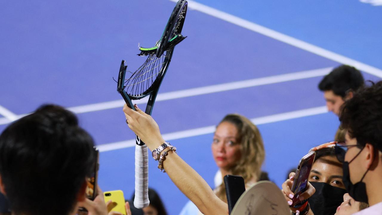 A woman holds the broken racquet of German Alexander Zverev. Photo by Marcos DOMINGUEZ / Abierto Mexicano de Tenis / AFP