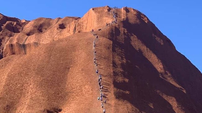 Tourists form a steady stream of climbers on Uluru on Wednesday. Picture: ABC