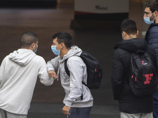 People wearing masks elbow greet at the front of Westfield Bondi Junction. Picture: Getty Images