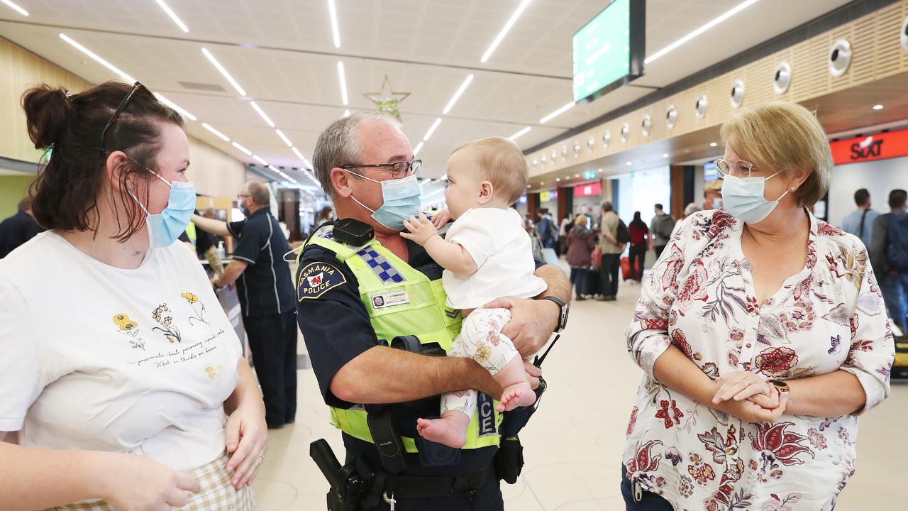 Tasmania Police Senior Constable Paul Edwards who was working at the airport on day 1 of border reopening reunited with granddaughter Isla 7 months from Newcastle who have been separated since she was 4 weeks old. Mum Lauren Edwards and grandmother Debbie Edwards look on. Picture: Nikki Davis-Jones