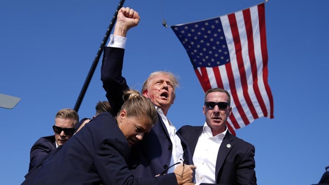 Republican presidential candidate Donald Trump is surrounded by U.S. Secret Service agents at a campaign rally in Butler, Pa, as he uttered his 'Fight Fight Fight!' catchphrase. (AP Photo/Evan Vucci)