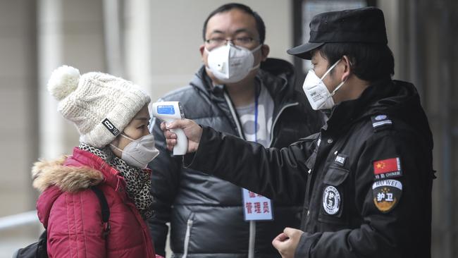 Security personnel check passenger temperatures at the wharf on the Yangtze River in Wuhan, Hubei province, China, on Thursday. Picture: Getty Images