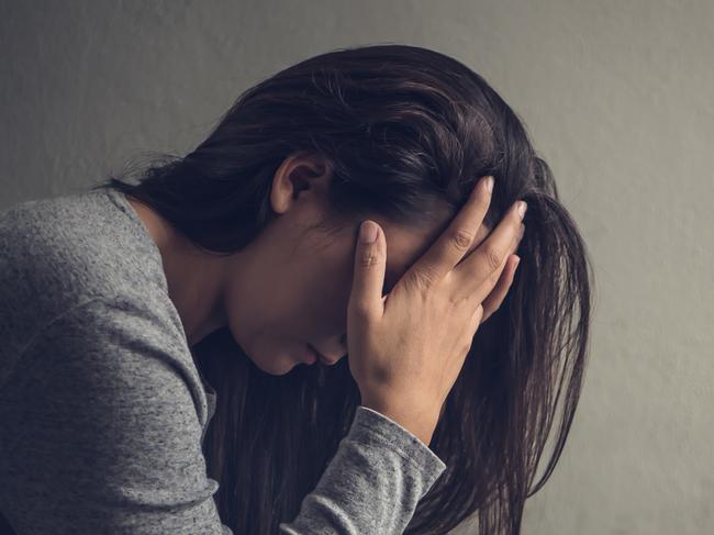 Depressed woman sitting on a chair in dark room at home. Lonly , sad, emotion concept.