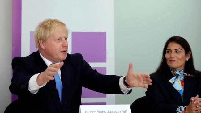 Britain's Prime Minister Boris Johnson (L), accompanied by Britain's Home Secretary Priti Patel, speaks at the first meeting of the National Policing Board at the Home Office in London, on July 31, 2019. (Photo by Kirsty Wigglesworth / POOL / AFP)