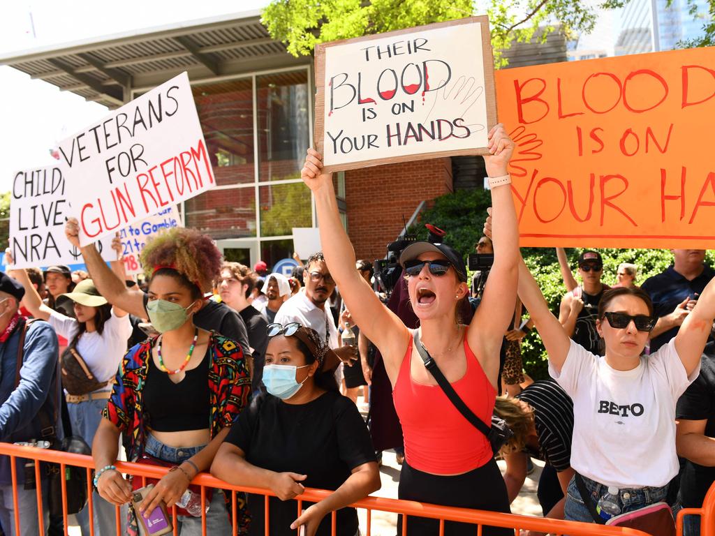 Protesters in support of gun control hold signs outside the National Rifle Association Annual Meeting in Houston.