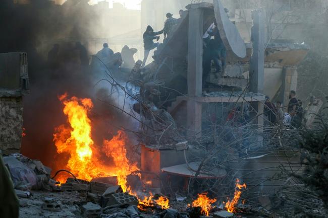 Volunteers try to put out a fire after an Israeli air strike in the east Lebanon city of Baalbek