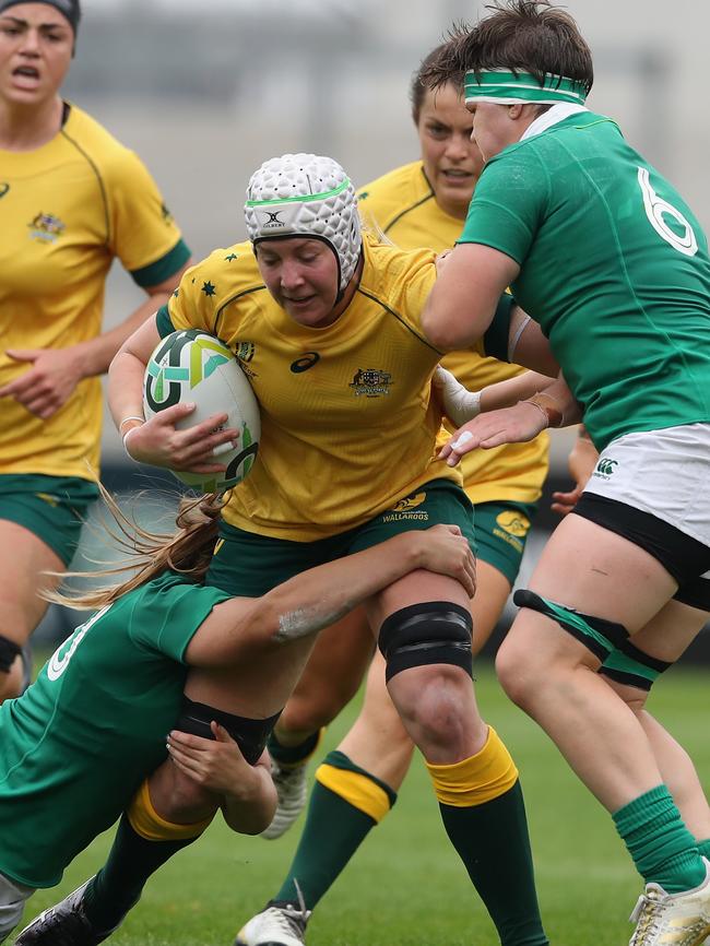 Chloe Butler of Australia is tackled by Nora Stapleton (L) and Ciara Griffin.