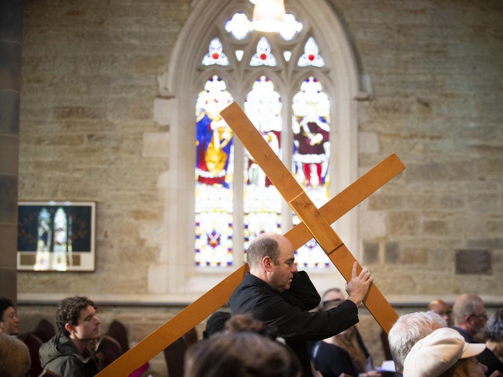 The Very Reverend Richard Charles Humphrey carries the cross at the start of the Solemn Meditation on The Seven Words from the Cross Good Friday service at St David’s Cathedral, Hobart. Picture: RICHARD JUPE