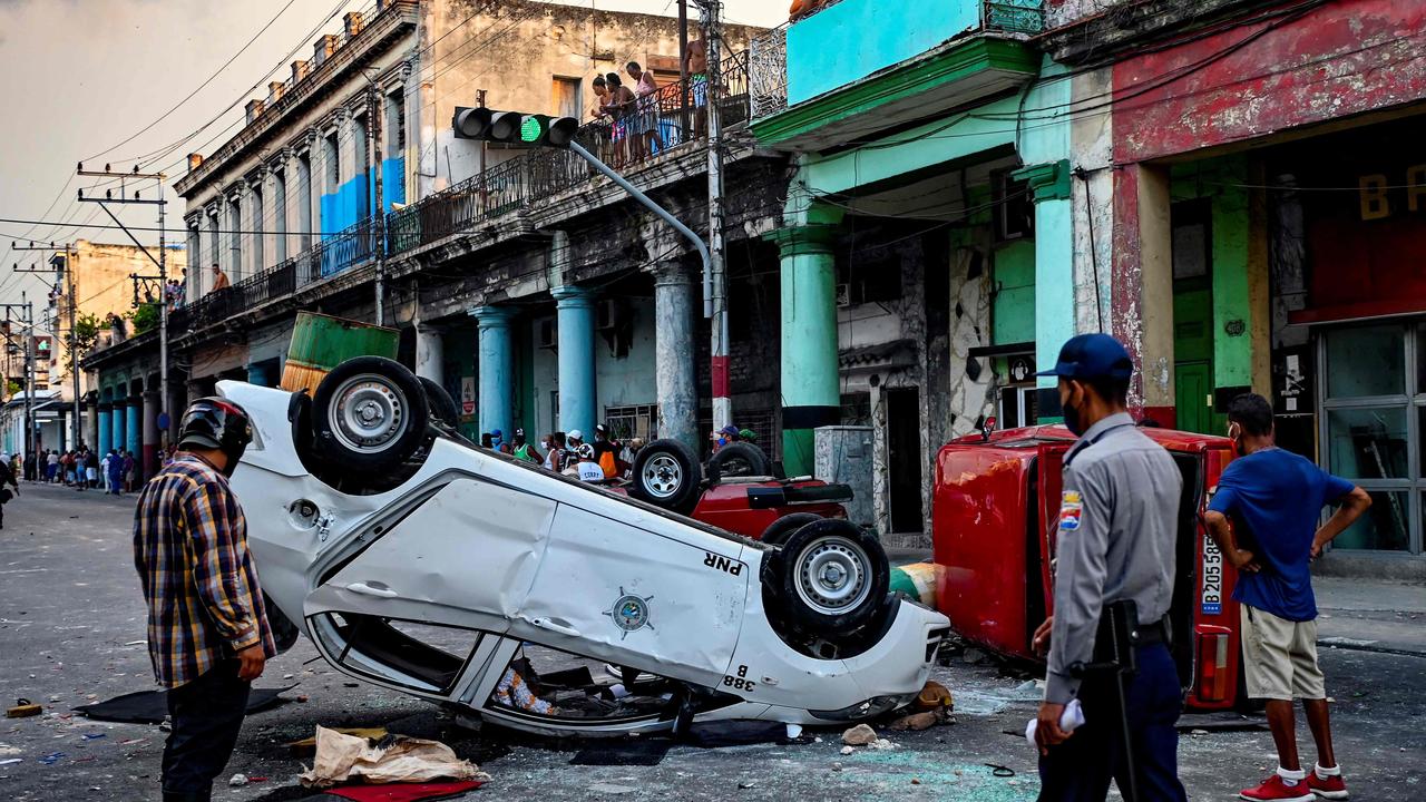 Overturned police cars on the streets of Havana. Picture: Yamil Lage/AFP