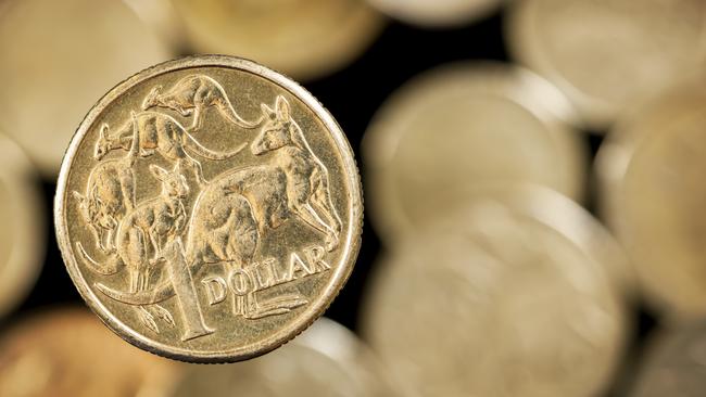 Australian one dollar coin over blurred golden background.