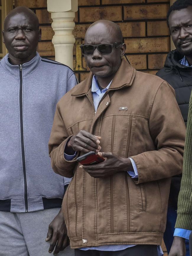 Family members gather outside Atem Kuany’s home with his father Elijah (front). Picture: Roy VanDerVegt