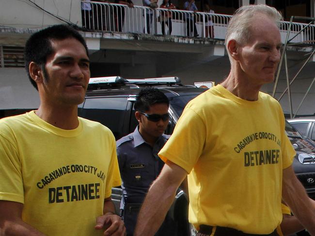 Peter Scully (right) handcuffed with another inmate.