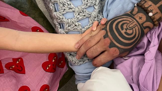 Remuna Avaemai holding his daughter's hand in a Gold Coast hospital. Picture: supplied