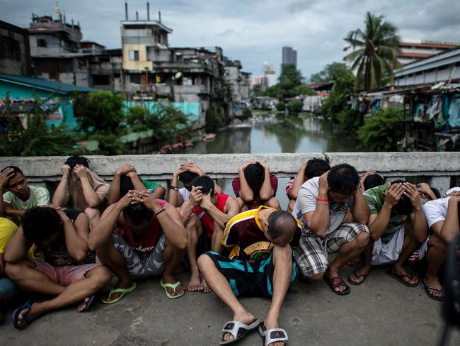Suspects are rounded up during an anti-drugs operation at an informal settlers’ community at the Manila Islamic Center on October 7, 2016. Picture: Noel Celis
