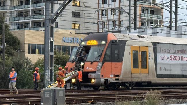 Workers are seen helping commuters get off the train