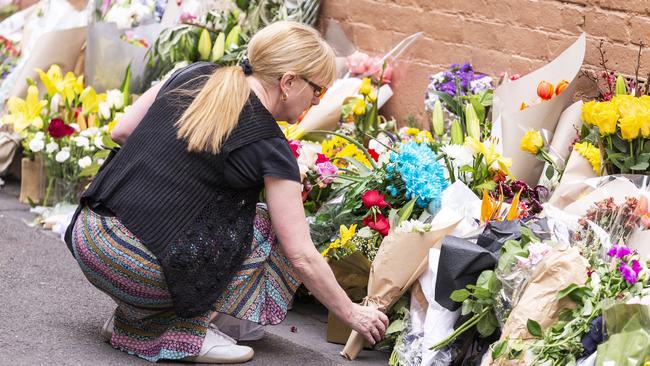 A woman lays flowers at a makeshift memorial for Bourke St attack victim Sisto Malaspina. Picture: AAP