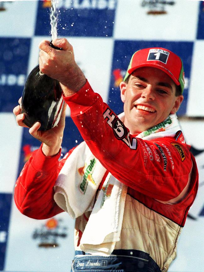 Racing driver Craig Lowndes spraying champagne after a win, 1999.