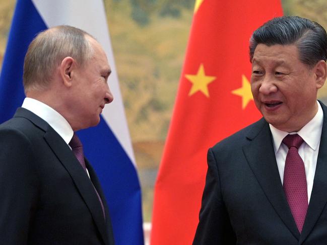 Russian President Vladimir Putin (L) and Chinese President Xi Jinping arrive to pose for a photograph during their meeting in Beijing, on February 4, 2022. (Photo by Alexei Druzhinin / Sputnik / AFP)