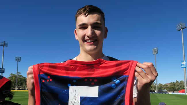 Julian Browne says he came down to game for his birthday. He holds a guernsey he just got signed by Christian Petracca, and reckons the Dee's will get up by 30 points.