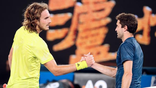 Greece's Stefanos Tsitsipas, left, shakes hands after winning against France's Gilles Simon in Melbourne on Tuesday night. Picture: AFP