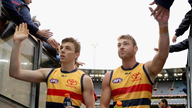 Jake Lever and Daniel Talia give high fives fans after winning against Carlton at the MCG. (Photo by Quinn Rooney/Getty Images)