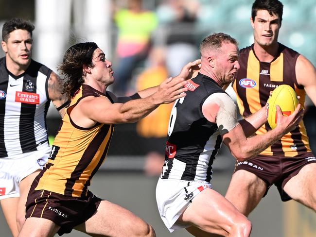 Tom Mitchell of the Magpies is tackled by Jai Newcombe of the Hawks during the AFL practice match in 2023. (Photo by Steve Bell/Getty Images)