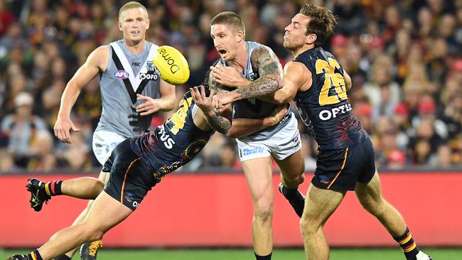 Hamish Hartlett breaks through a double tackle against the Crows. Picture: AAP Images