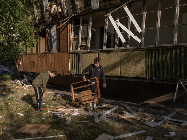 Men clean debris of a building damaged in the missile attack on Kyiv, Ukraine. Picture: Getty Images