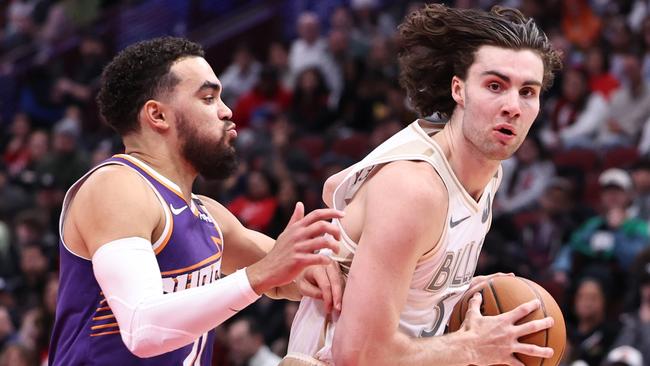 CHICAGO, ILLINOIS - FEBRUARY 22: Josh Giddey #3 of the Chicago Bulls dribbles past Tyus Jones #21 of the Phoenix Suns during the second quarter at the United Center on February 22, 2025 in Chicago, Illinois. NOTE TO USER: User expressly acknowledges and agrees that, by downloading and or using this photograph, User is consenting to the terms and conditions of the Getty Images License Agreement. (Photo by Geoff Stellfox/Getty Images)