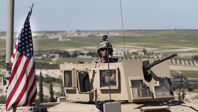 A US soldier sits in an armoured vehicle on a road leading to the tense front line with Turkish-backed fighters, in Manbij, north Syria. Picture; AP.