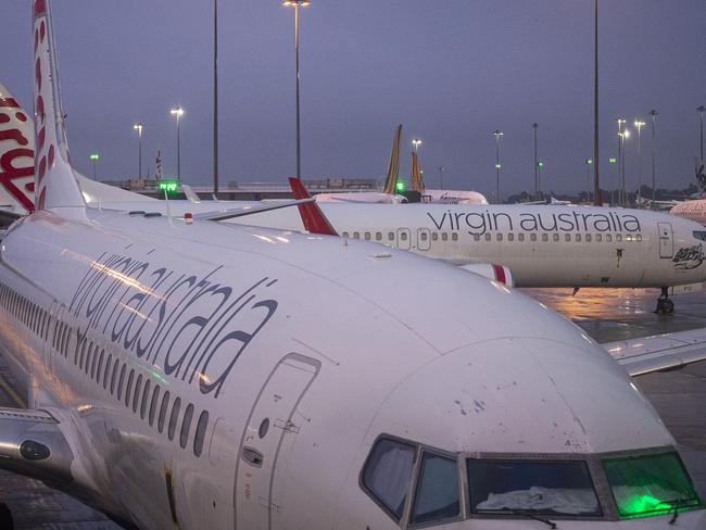 MELBOURNE, AUSTRALIA - JULY 07: Virgin aircraft are seen at Tullamarine Airport on July 07, 2020 in Melbourne, Australia. The NSW-Victoria border will close at 11:59pm on Tuesday evening due to a large spike in COVID-19 cases in Victoria. It is the first time in 100 years the border between the two states has been closed, and comes after Victoria recorded its highest-ever daily increase in cases, 127, since the start of the pandemic on Monday, along with the deaths of two Victorian men. From 12:01 Wednesday 8 July, NSW residents returning from Victoria will need to self isolate for 14 days. Special provisions will be in place for border communities such as Albury-Wodonga as well as freight operations and other critical services. (Photo by Daniel Pockett/Getty Images)