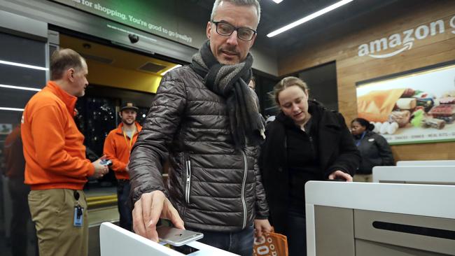 A customer scans his Amazon Go cellphone app at the entrance as he heads into the Amazon Go store. Picture: AP.