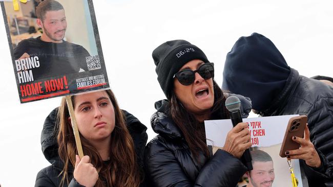 Relatives of Israeli hostages held by Hamas carry a picture of Itay Chen, 19, in Kibbutz Nirim along the Gaza border, equipped with powerful loudspeakers hanging from cranes, in an effort to get messages of hope across to them. Picture: AFP