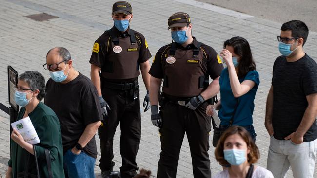 Security guards wearing face masks control visitors entering the Sagrada Familia basilica in Barcelona. Picture: AFP.