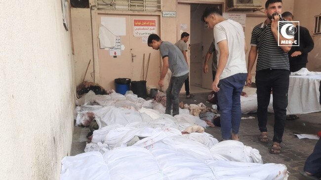 Bodies wrapped in white shrouds await collection outside the Indonesian Hospital