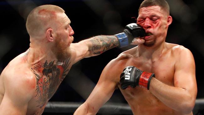 Conor McGregor (L) hits Nate Diaz at UFC 202.