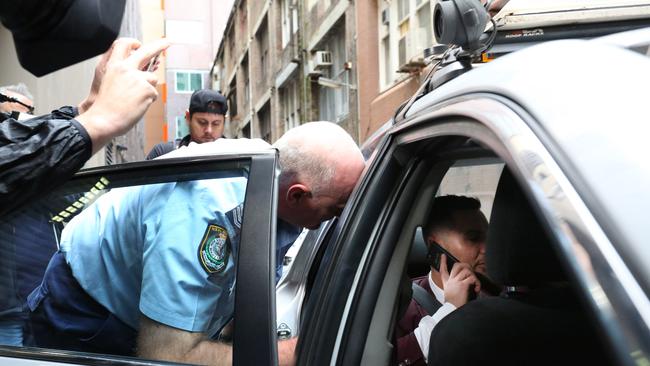 An officer ejects him from the taxi after the driver refused to take his fare. Picture: Brianne Makin