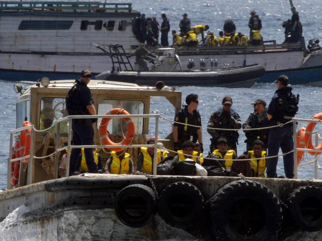 Another boatload of asylum-seekers after being intercepted heading for Australia by HMAS Albany, arrives at Flying Fish Cove on Christmas Island for processing, before being flown for detention in Malaysia under a recently signed refugee swap agreement between Australia and Malaysia.