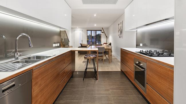 The modern kitchen has stainless steel appliances and a compact breakfast bar.