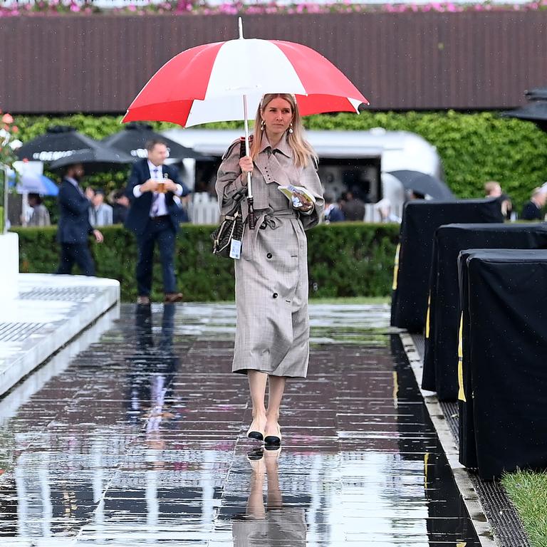 A trace fan walks through the members area after a downpour.