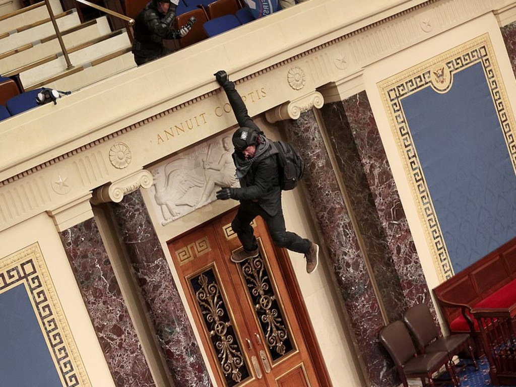 A protester hangs from a ledge inside the Capitol. Picture: Getty Images